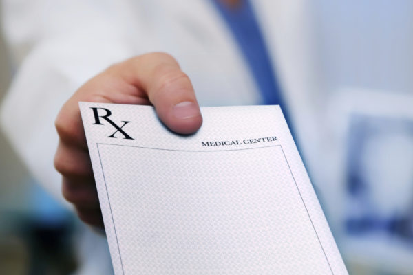 doctor holding out blank prescription pad